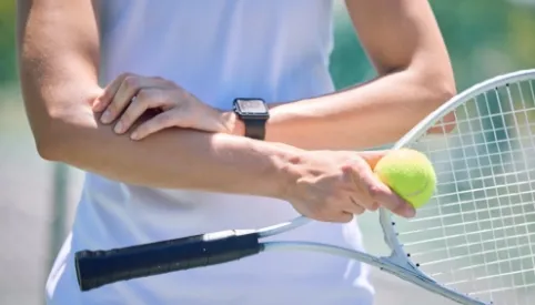 tennis player holding painful arm