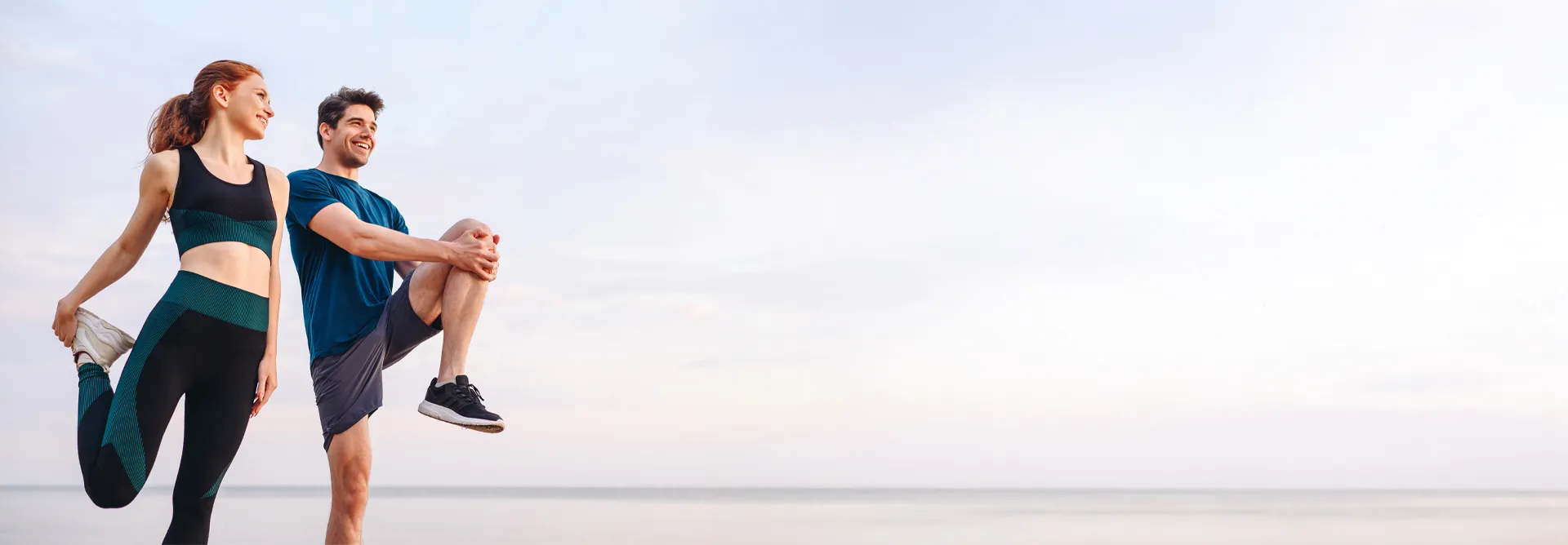 Male and female stretching before running