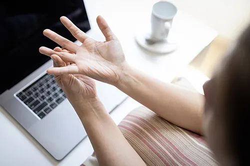woman holding painful finger